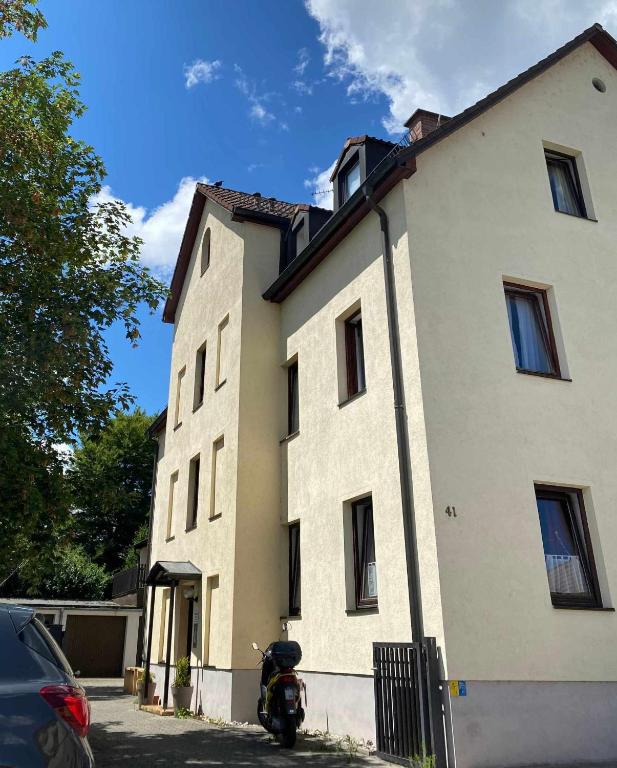 a white building with a motorcycle parked in front of it at Stadtdomizil in Augsburg