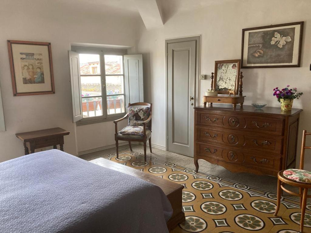a bedroom with a bed and a dresser and a chair at ATTICO IN PIAZZA SANTA CROCE in Florence