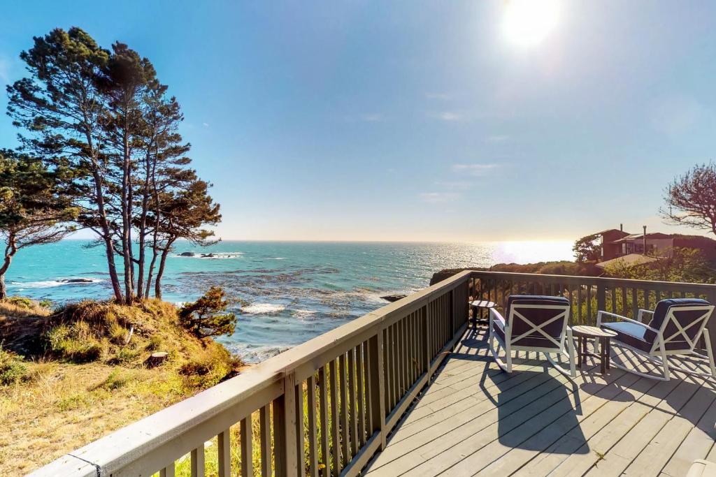 una terraza con sillas y vistas al océano. en Otter's Rest, en Gualala