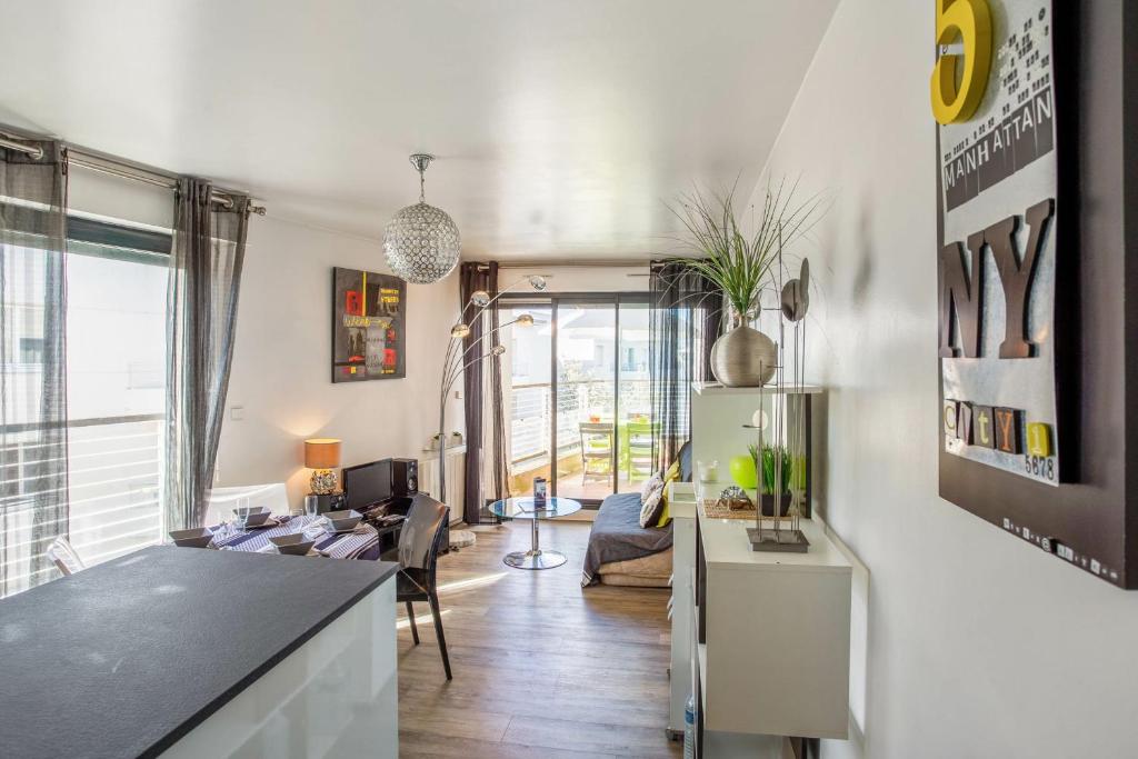 a kitchen and a living room with a refrigerator at Appartement Goélette - Welkeys in La Rochelle