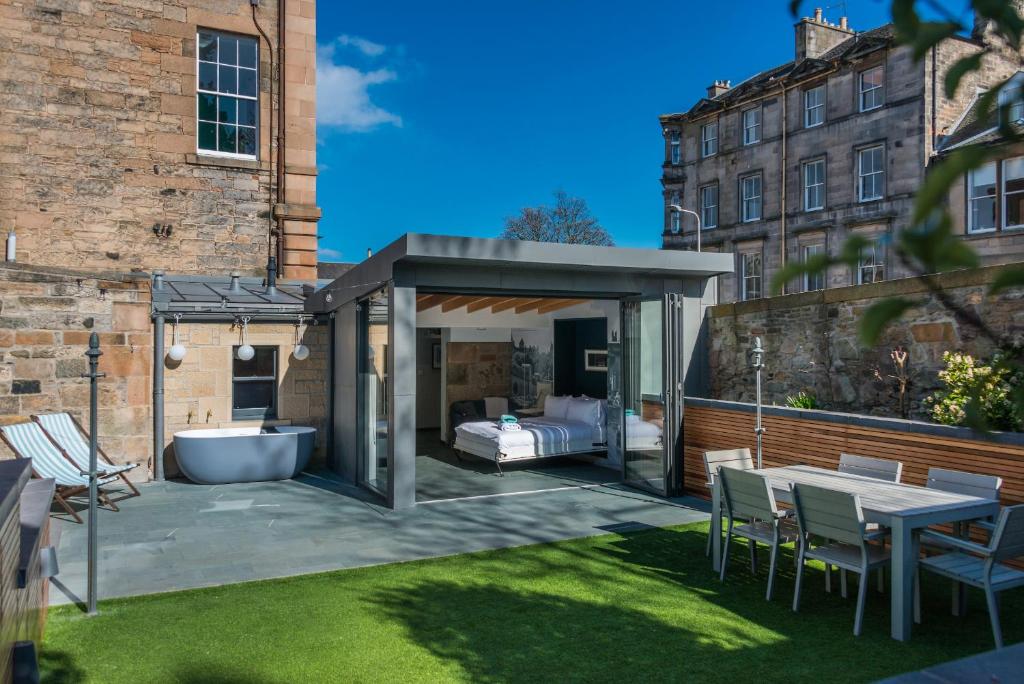 een tuinhuisje met een bed en een bad in de tuin bij Garden Rooms Edinburgh in Edinburgh