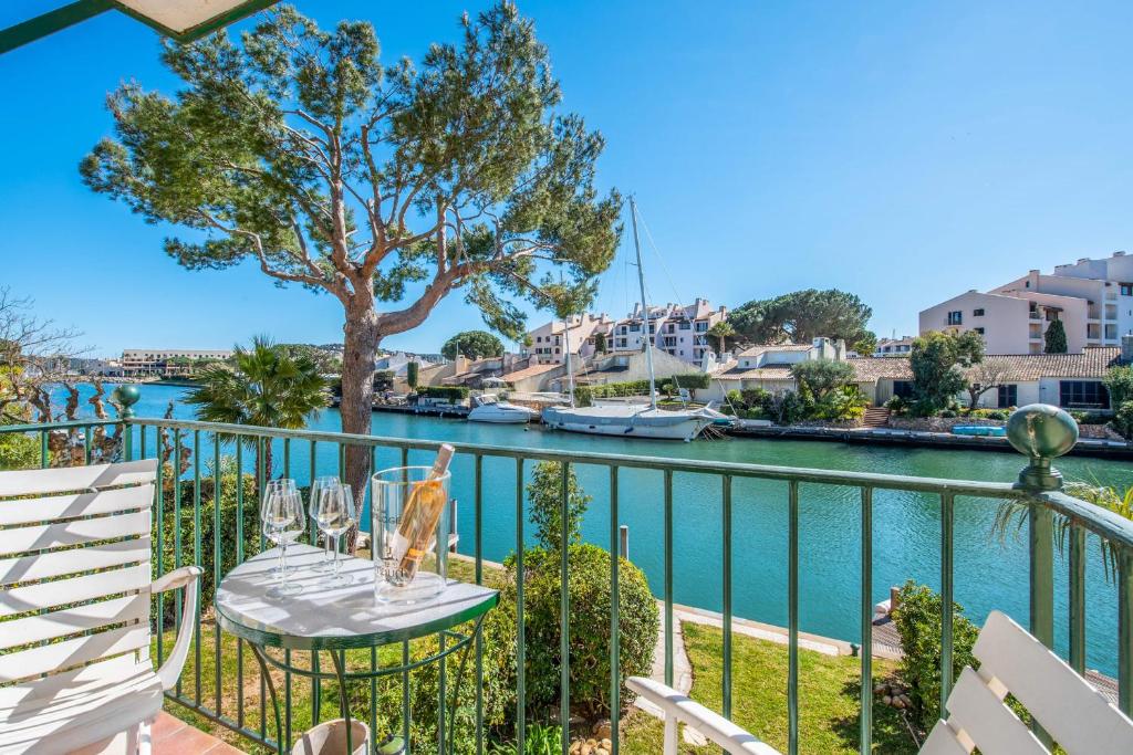 a balcony with a table and chairs next to a river at Appartement Saphir - Welkeys in Grimaud