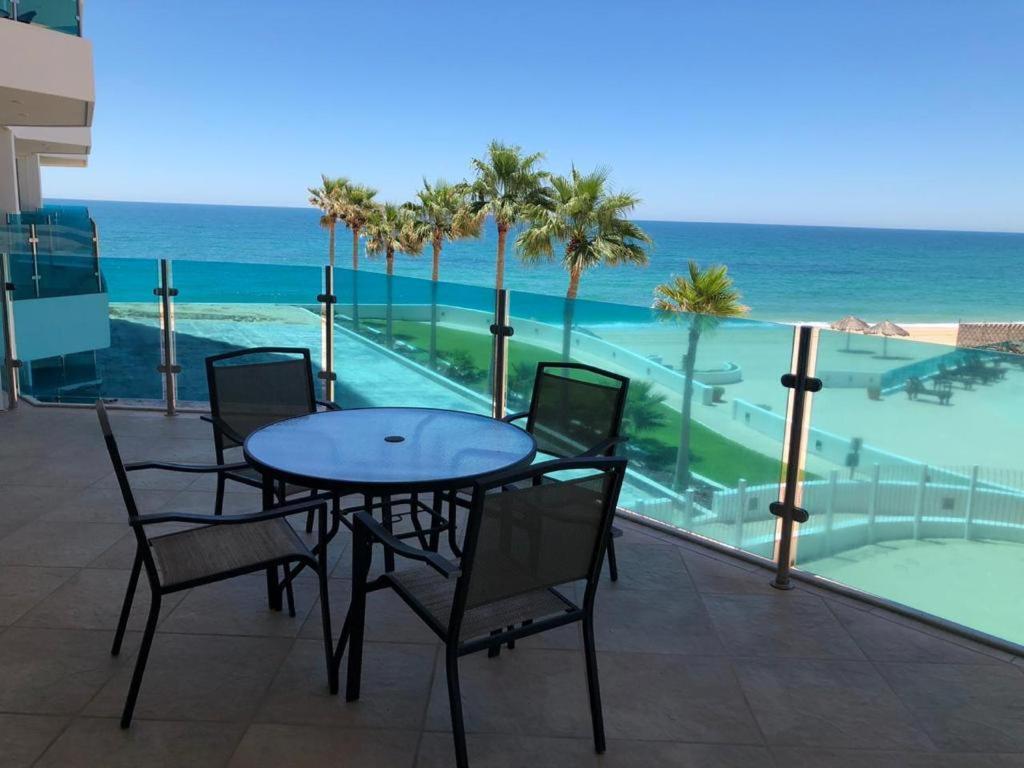 a table and chairs on a balcony with the ocean at ESMERALDA B-201 in Puerto Peñasco