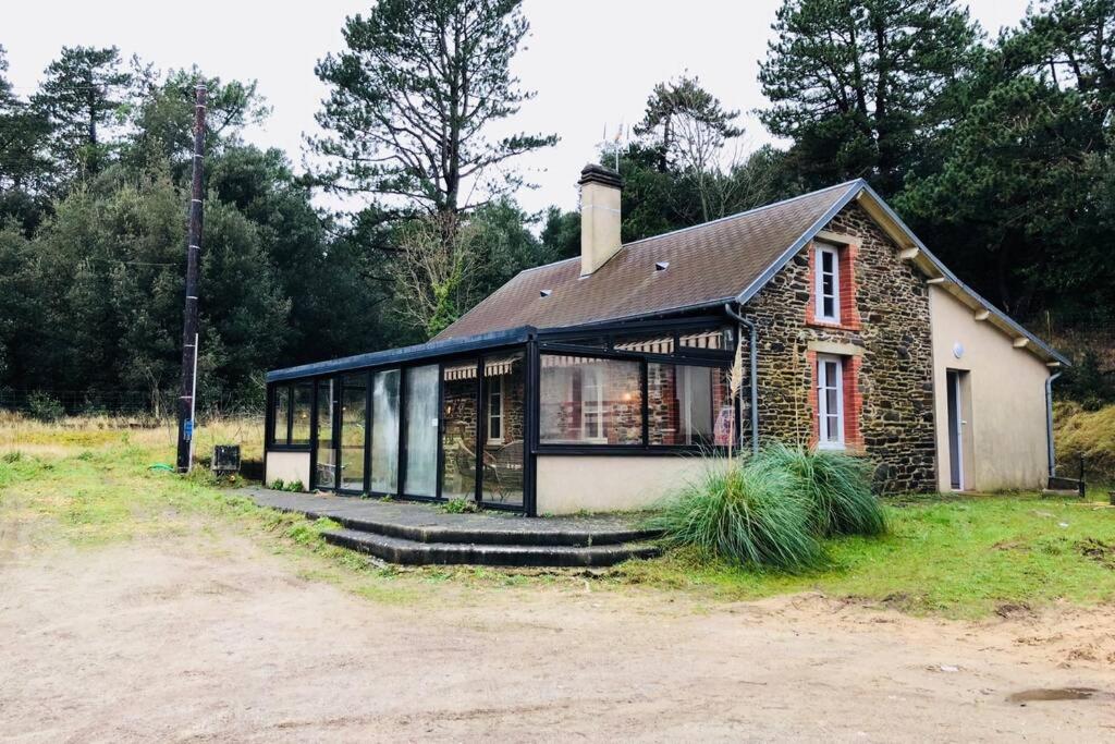 a small brick house with windows on a field at La Vallée Entre dunes et mer, un véritable havre de paix in Barneville-Carteret