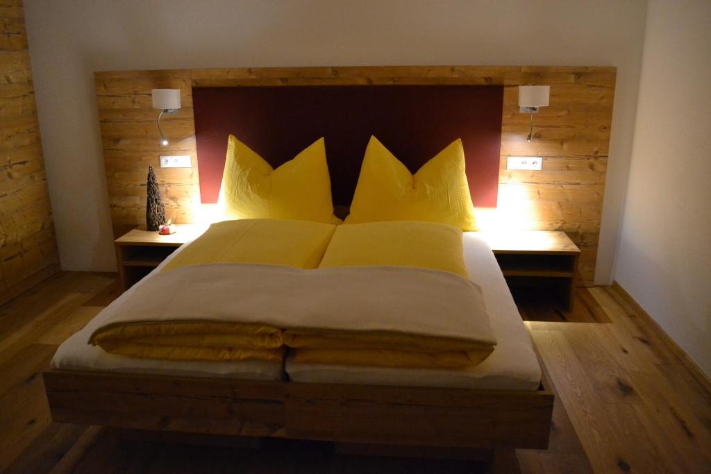 a bedroom with a large bed with yellow pillows at Landhaus Waldesruh in Oetz