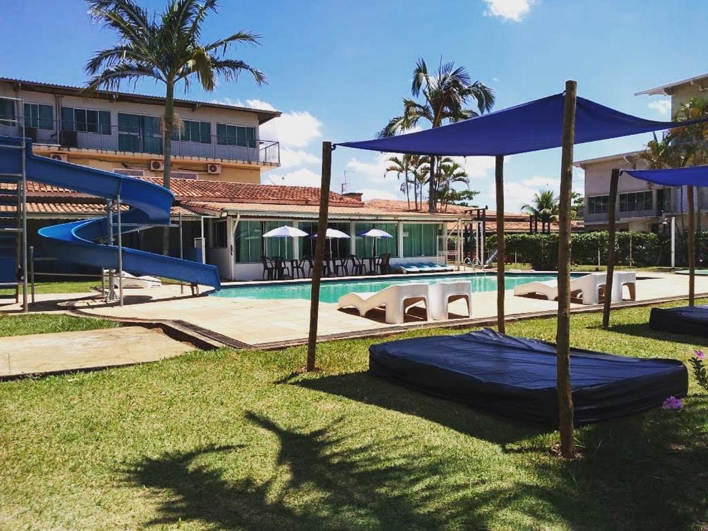 a swimming pool with a blue slide and a playground at Pousada das Estrelas Atibaia in Atibaia