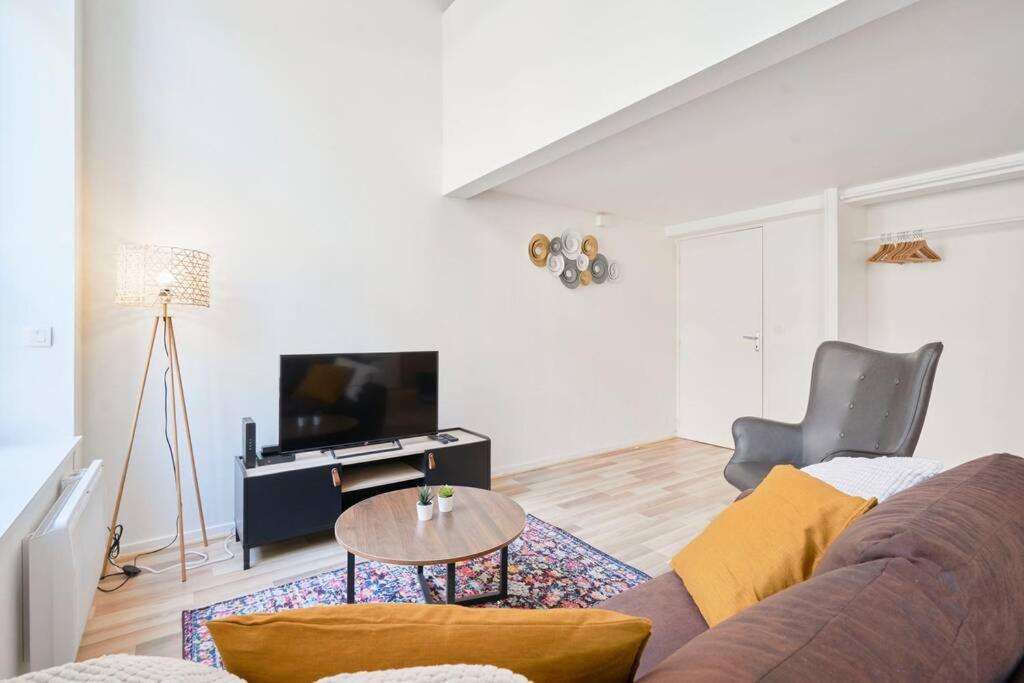 un soggiorno con divano e tavolo di LocationsTourcoing - Le Loft a Tourcoing