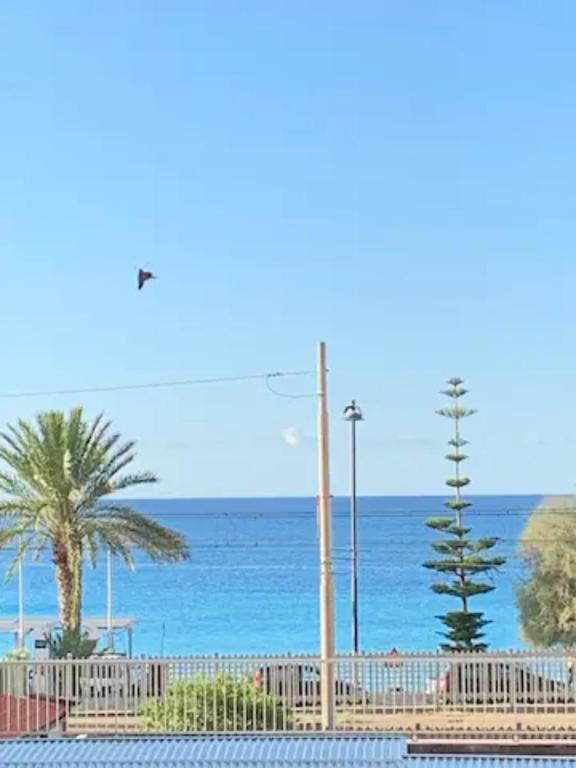 a view of the ocean from a beach with a street light at Nido d'amore vista mare in Bordighera