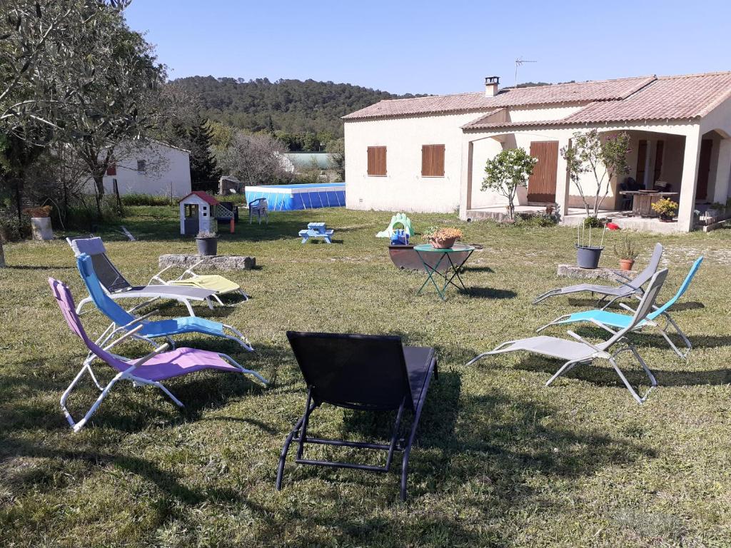 un grupo de sillas de jardín sentadas en el césped en Location villa saisonniere a la campagne, en Saint-Théodorit