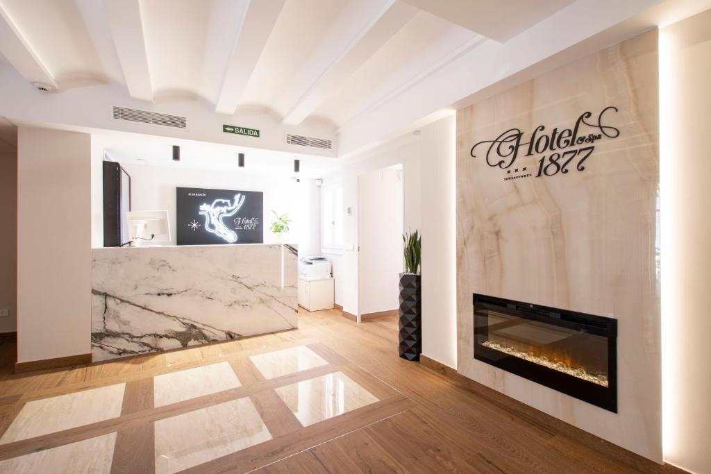 a living room with a fireplace and a sign on the wall at Hotel 1877 Sensaciones & SPA ADULTS ONLY in Albarracín