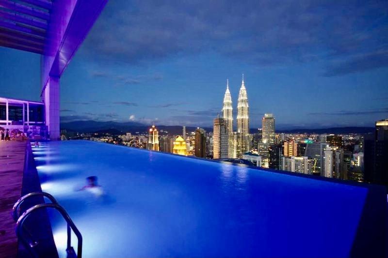 a swimming pool with a city skyline at night at Platinum Serviced Suite KLCC in Kuala Lumpur