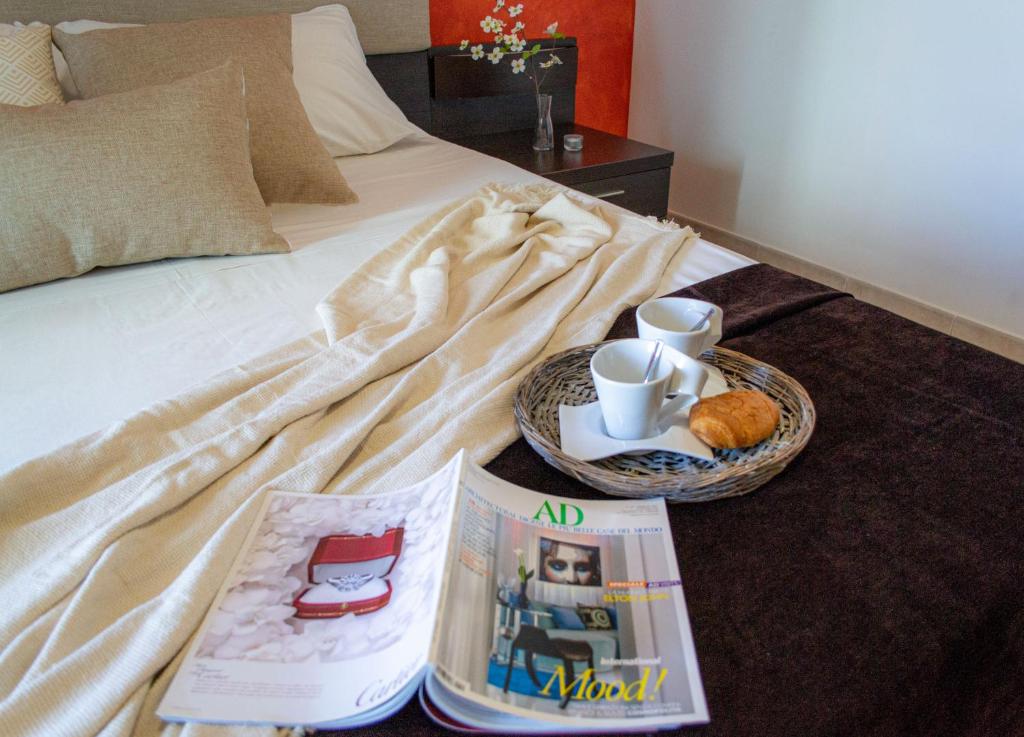 ein Bett mit einem Tablett mit Essen und Büchern darauf in der Unterkunft Residence Borgo & Mare - Localo in Melendugno