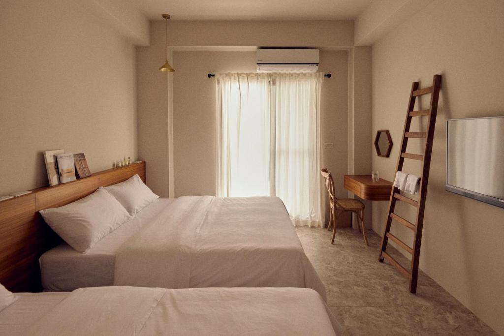 una camera con 2 letti, una scala e una scrivania di Sunlight Homestay a Magong