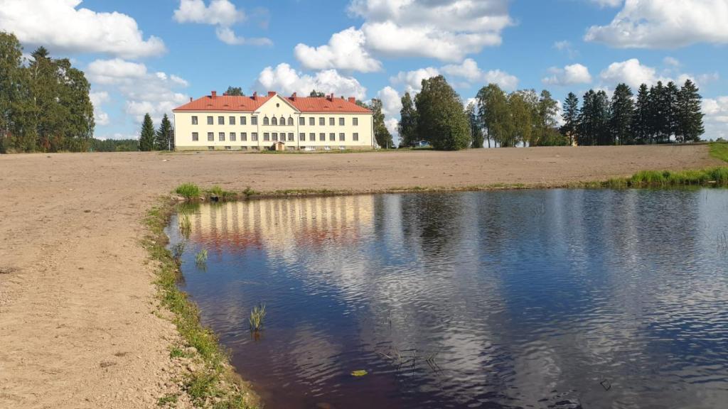 Nivala的住宿－Jokihovi，一座大型白色建筑,毗邻水体