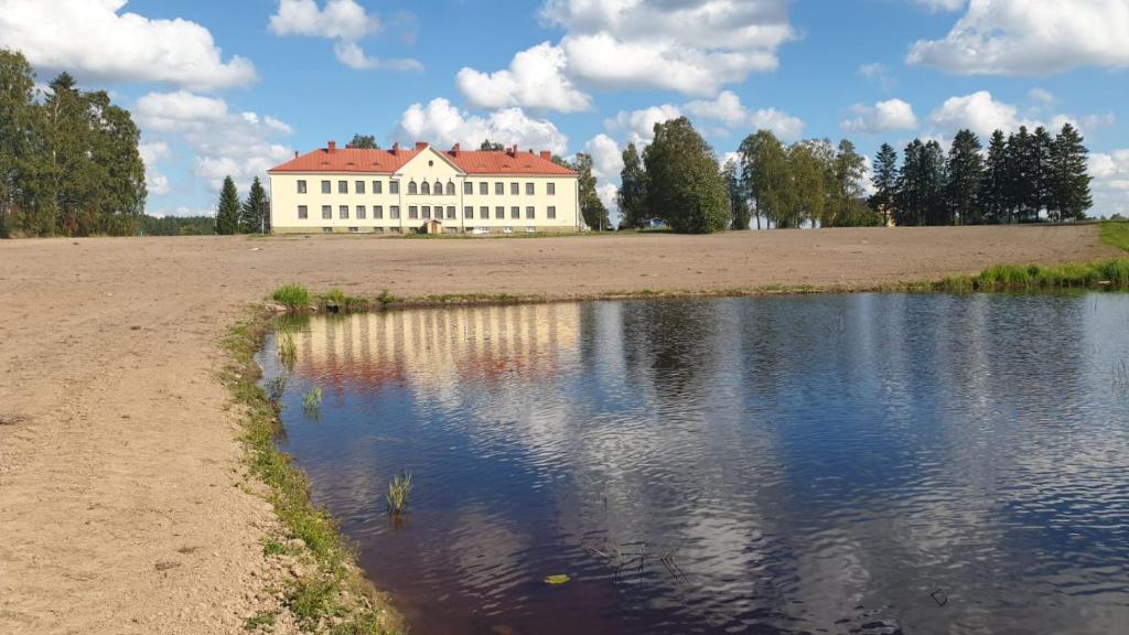 a large white building sitting next to a body of water at Jokihovi in Nivala