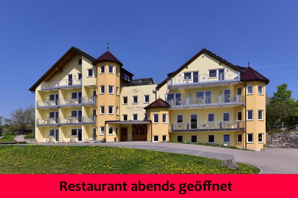 een groot geel gebouw met de woorden restaurant verslaafden getert bij Hotel Wender in Vehlberg