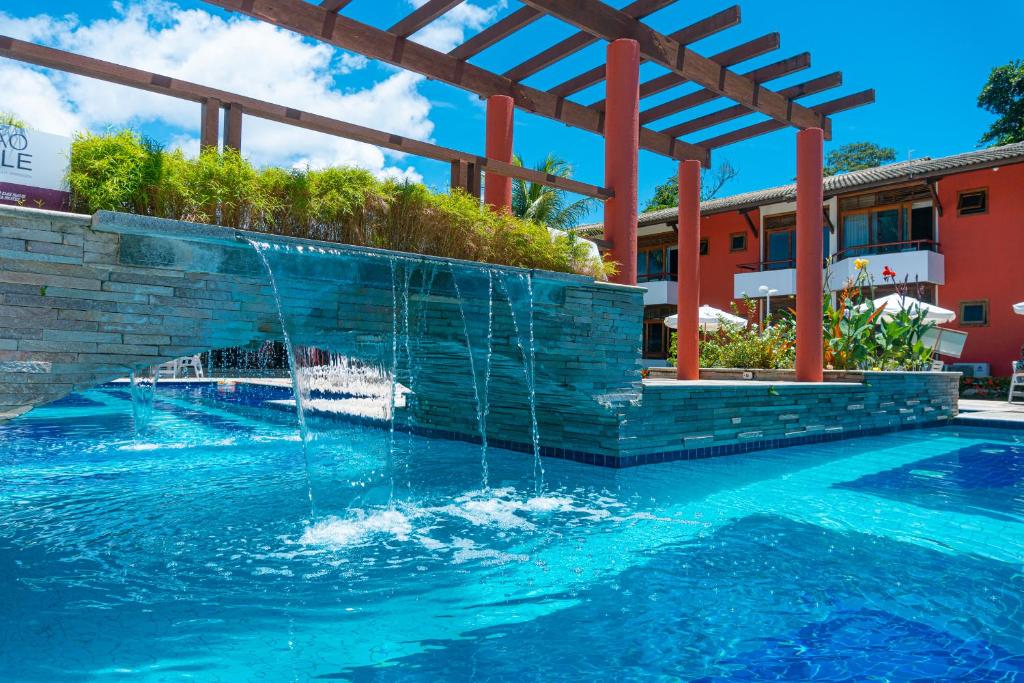 una piscina con una fuente de agua en Porto das Naus Praia Hotel, en Porto Seguro