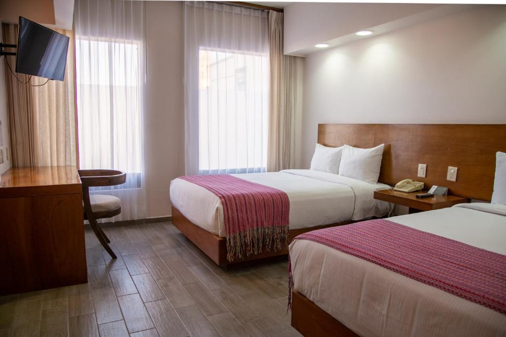 Postel nebo postele na pokoji v ubytování Hotel Alameda Centro Historico