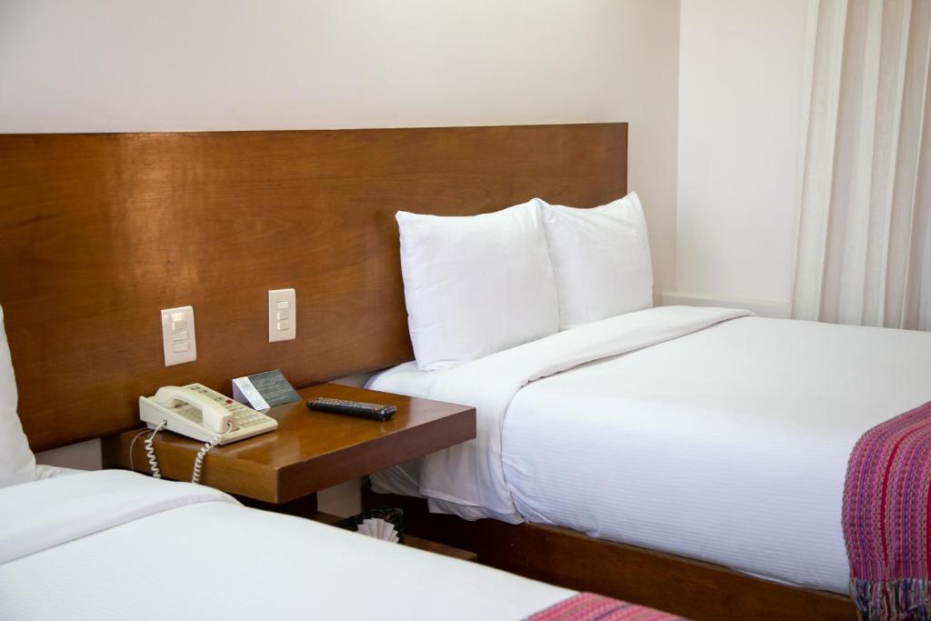 Postel nebo postele na pokoji v ubytování Hotel Alameda Centro Historico