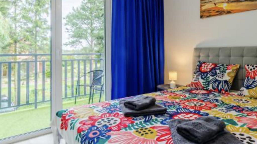 ein Schlafzimmer mit einem Bett und einem Balkon in der Unterkunft Apartament San in Łeba