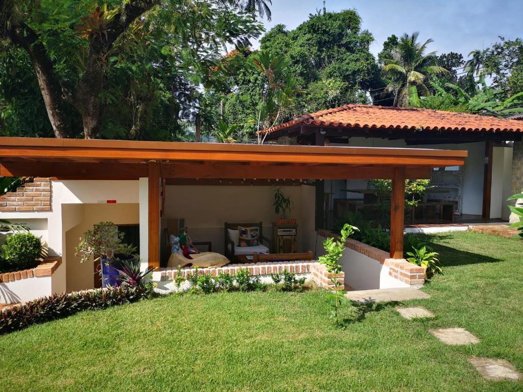 a house with a wooden pergola in a yard at Boutique Hotel Carpe Diem in Paraty