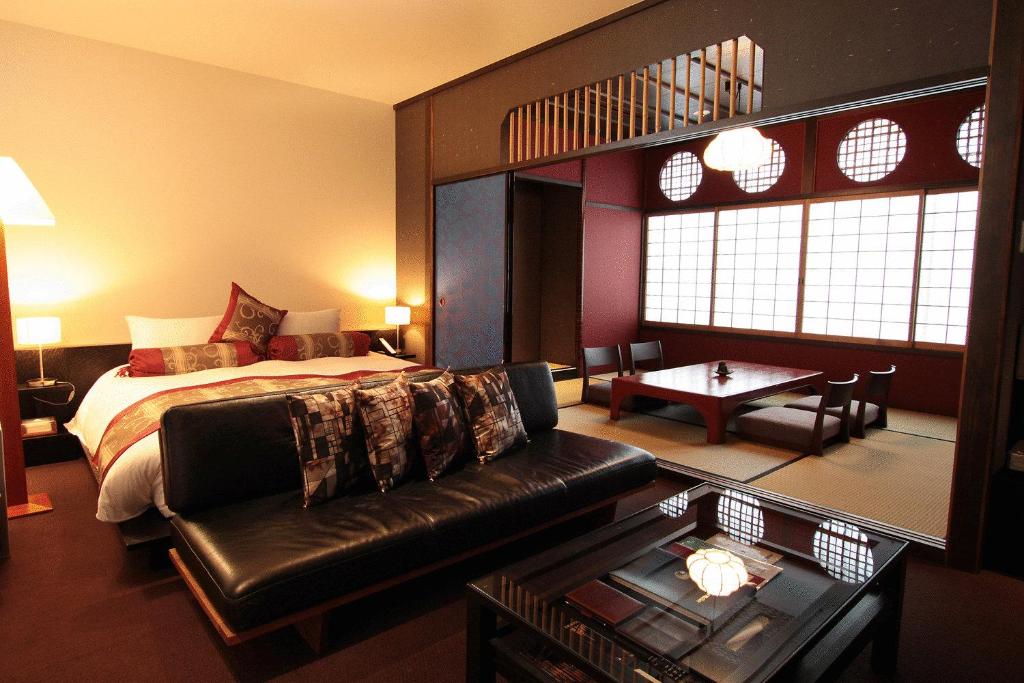 a hotel room with a bed and a couch at Kizashi The Suite 京都祇園 in Kyoto