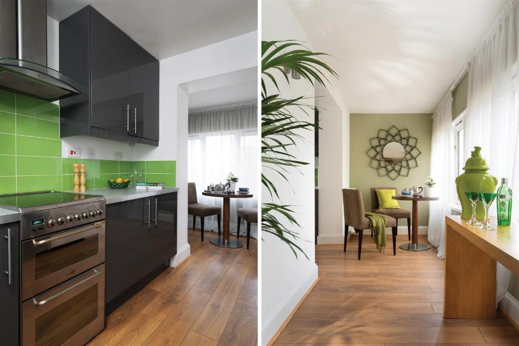 a kitchen with black appliances and a dining room with green at Palm Grove Apartments in Torquay