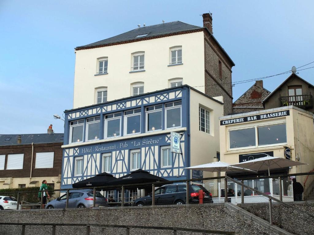 a building with a blue and white sign on it at Hôtel La Sirène in Yport