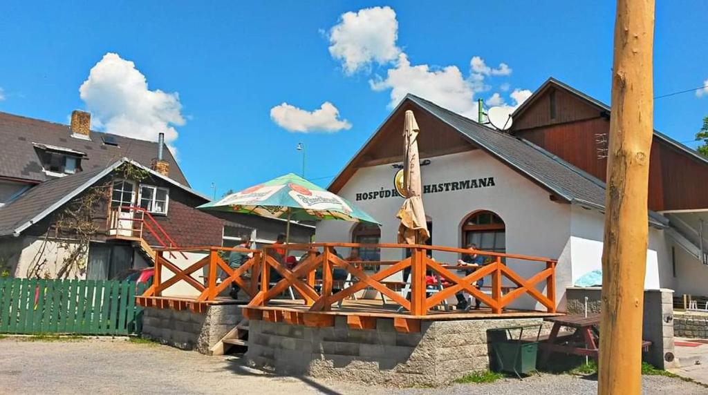 ein Restaurant mit einer Holzbrücke vor einem Gebäude in der Unterkunft Apartmány u Hastrmana in Vyšší Brod