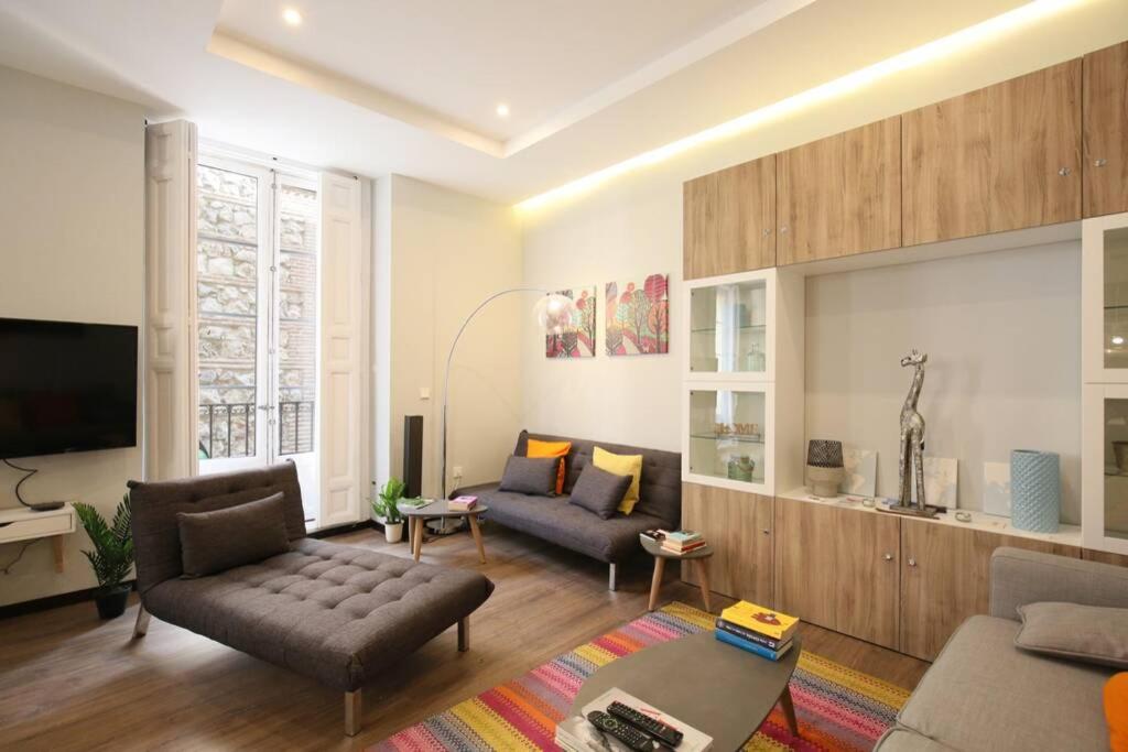 a living room with two couches and a tv at Agradable apartamento en el Madrid de los Austrias in Madrid