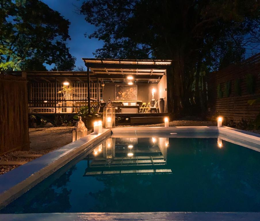 a swimming pool at night with a house in the background at Lush in Graskop