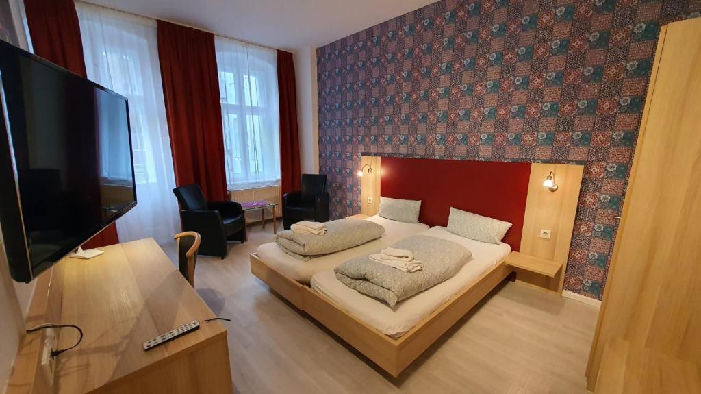 Schlafzimmer mit einem Bett und einem Flachbild-TV in der Unterkunft Bornholmer Hof im Prenzlauer Berg in Berlin