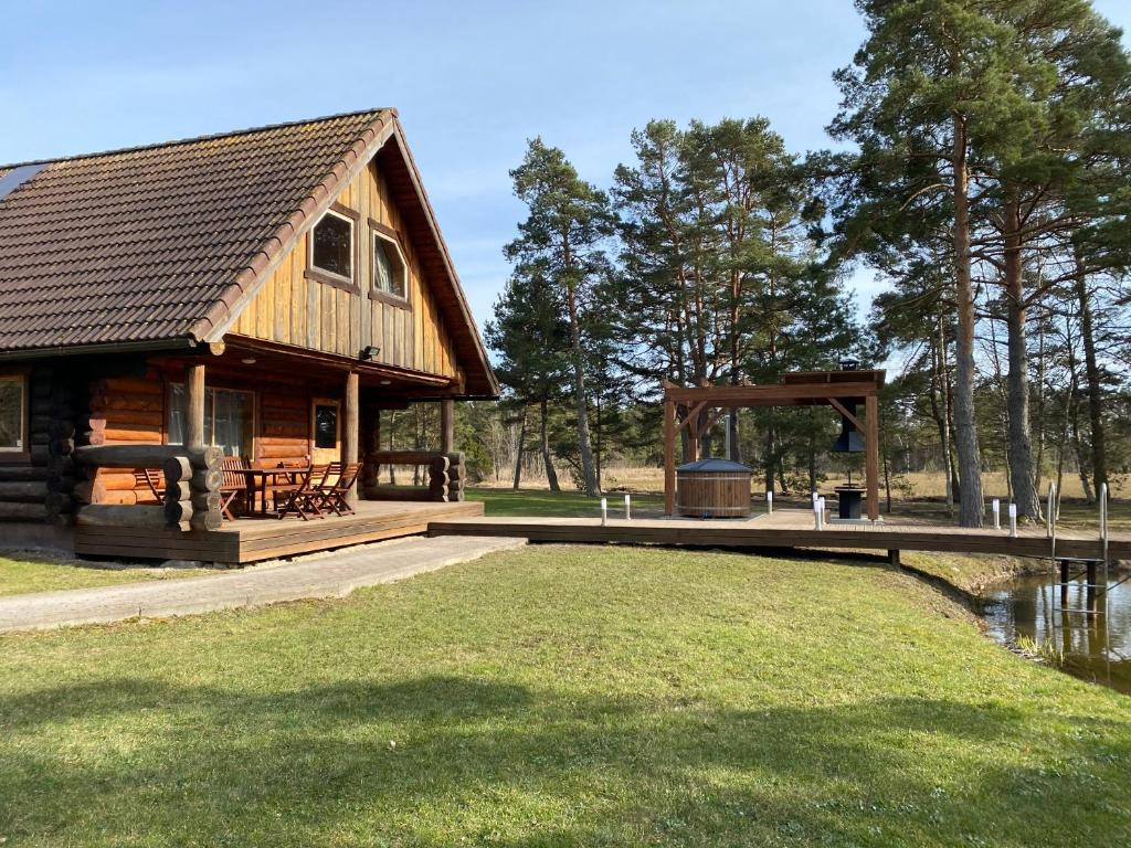 a log cabin with a dock and a playground at Soosaare Holiday House in Nasva