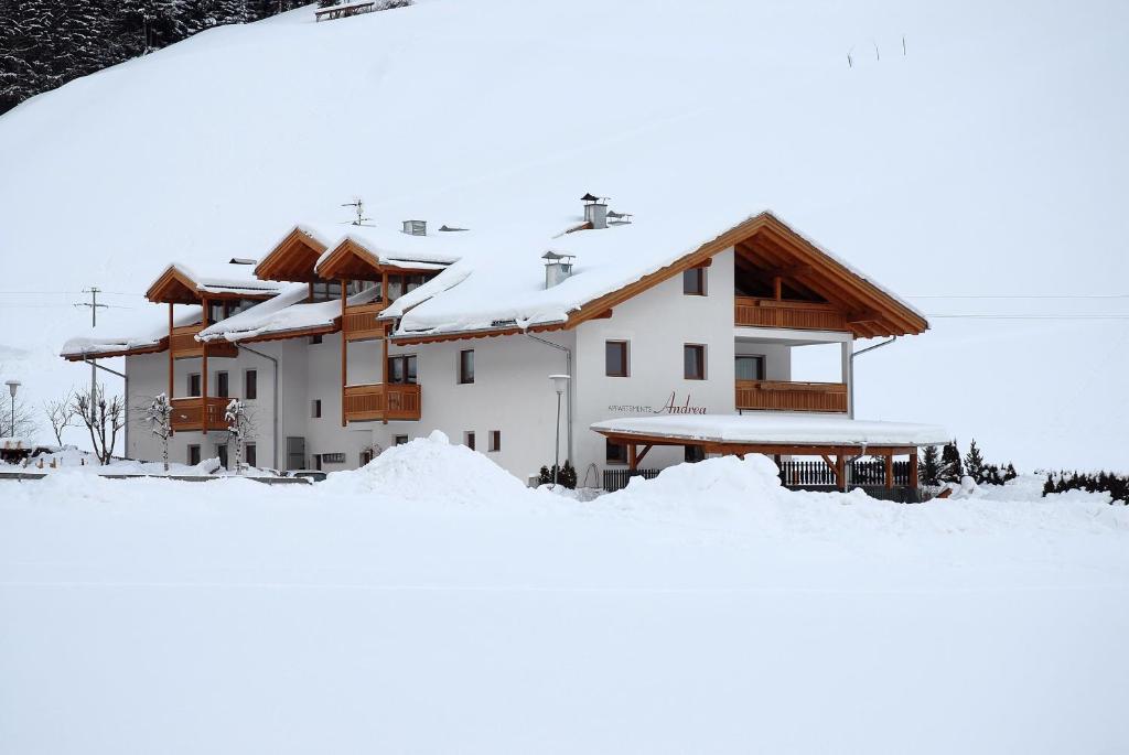 une maison recouverte de neige devant dans l'établissement Residence Andrea, à Cadipietra