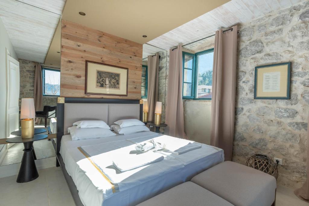 a bedroom with a king sized bed and a chair at Apartments Gabela in Risan