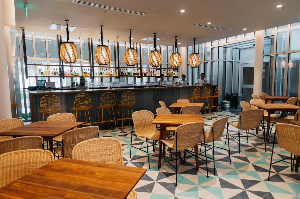 a restaurant with tables and chairs and a bar at Emporio Cancun - Buy All Inclusive Option in Cancún