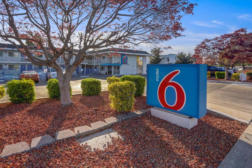 Motel 6-Napa, CA في نابا: لوحة ازرق مع رقم 6 امام شجرة