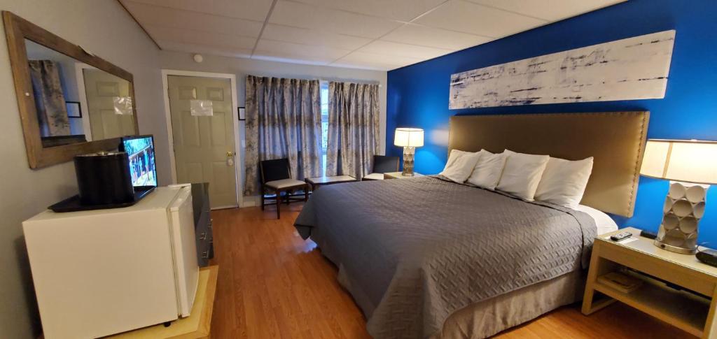 um quarto de hotel com uma cama e uma televisão de ecrã plano em Lido Motel Lake George em Lake George