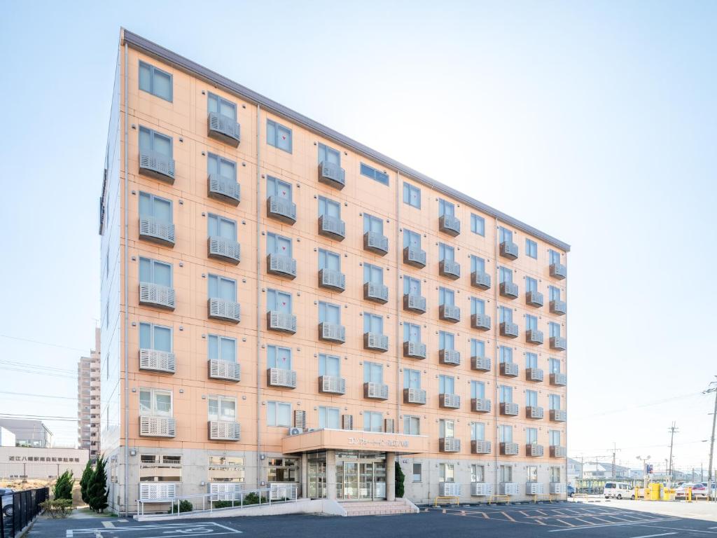 a large building with many windows in a parking lot at Comfort Inn Omihachiman in Omihachiman