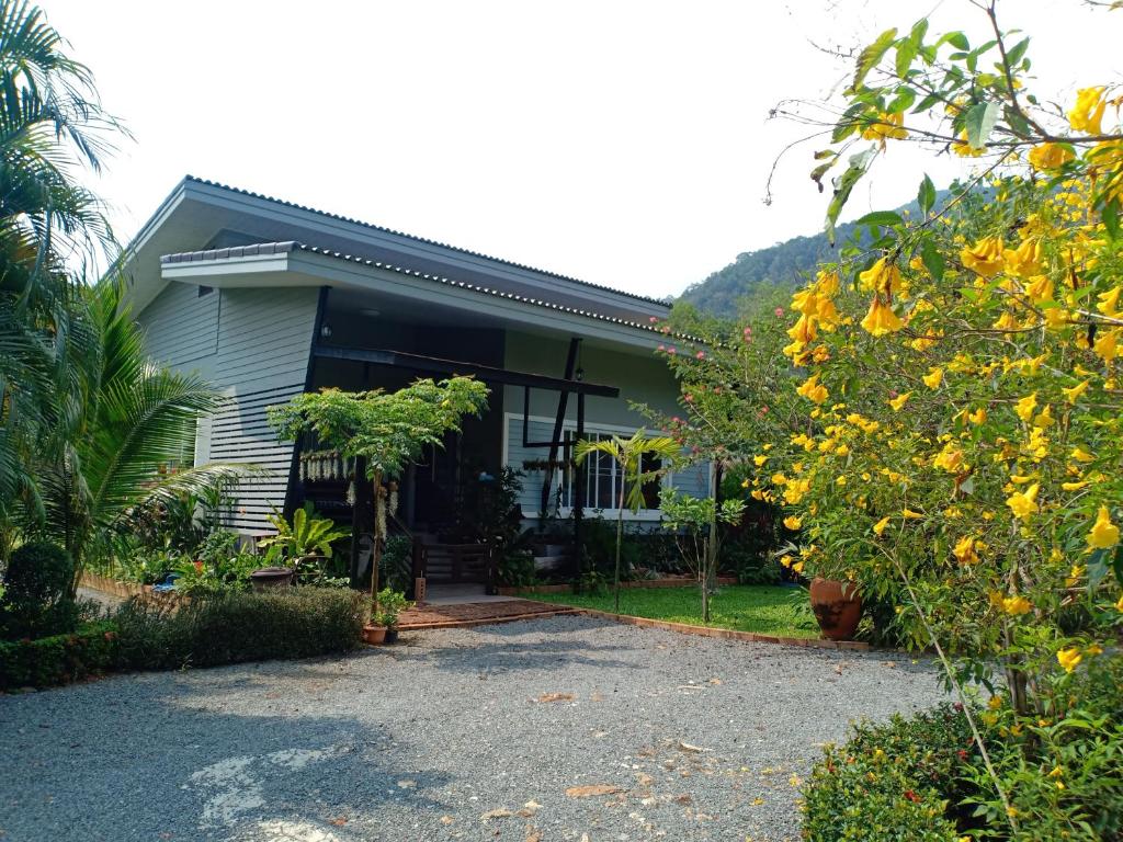 ein Haus mit einer Kiesauffahrt davor in der Unterkunft Sunbeam Cottage in Ko Chang
