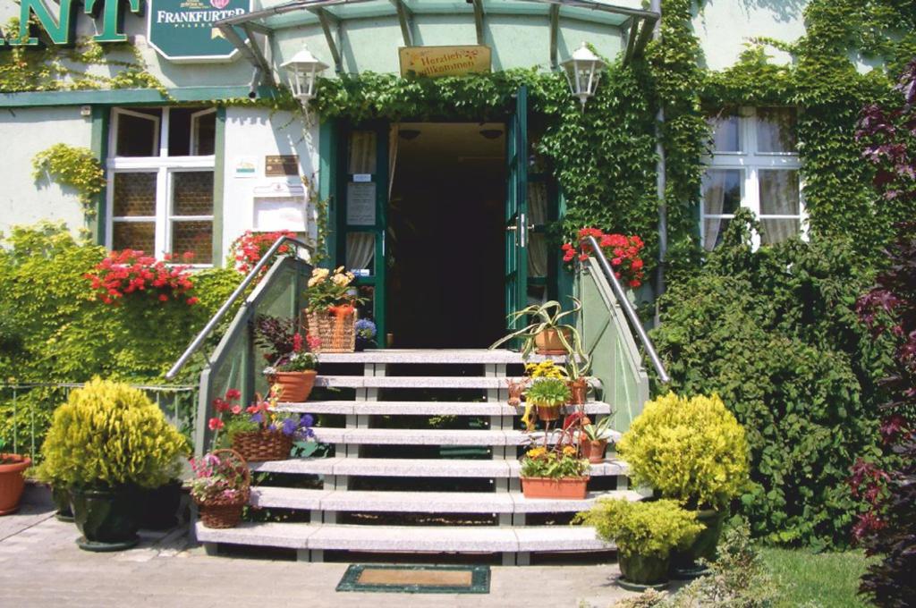 a staircase leading to a house with flowers and plants at Hotel &amp; Restaurant ,,Zur Alten Oder&quot; in Frankfurt-Oder in Frankfurt Oder