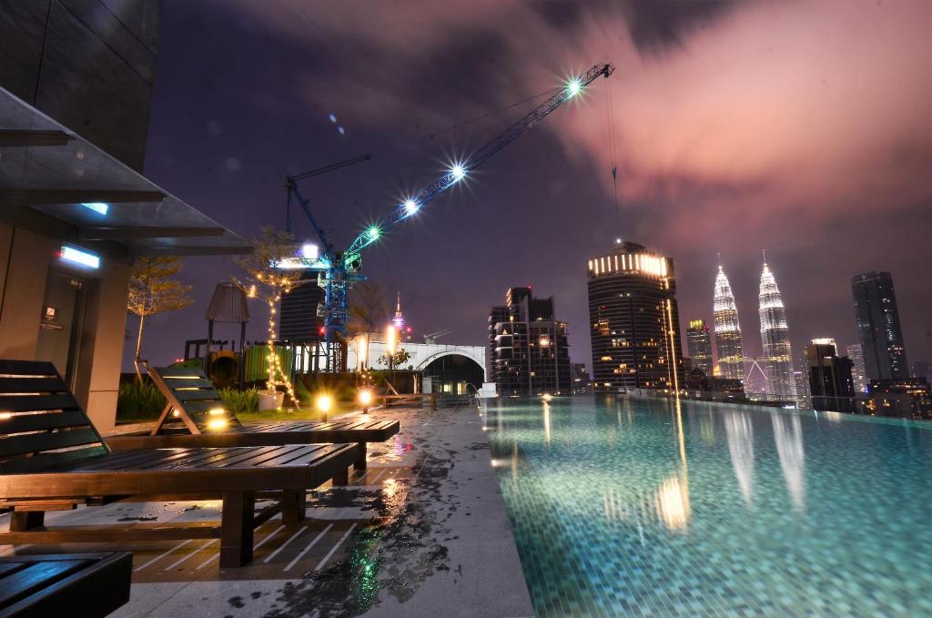 a rooftop pool with a city skyline at night at Dorsett Residences Bukit Bintang @Artez Maison in Kuala Lumpur