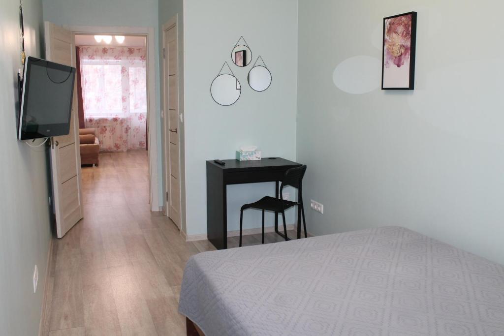 a bedroom with a bed and a table and a television at Амурский бульвар 5, Семейные Апартаменты в районе набережной in Khabarovsk