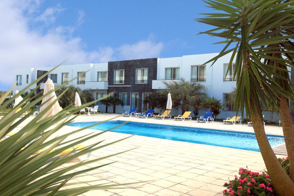 um resort com uma piscina em frente a um edifício em Acorsonho Apartamentos Turisticos em Capelas