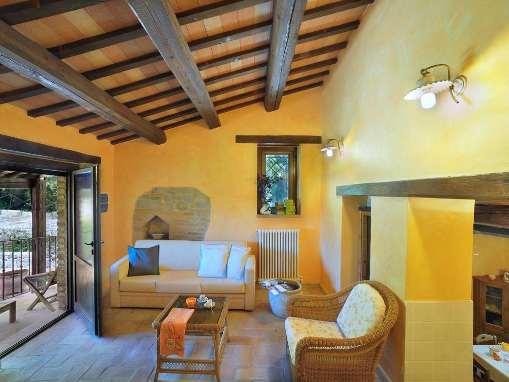 ein Wohnzimmer mit einem Sofa und einem Tisch in der Unterkunft Belvilla by OYO Il Rigogolo in SantʼAngelo in Pontano