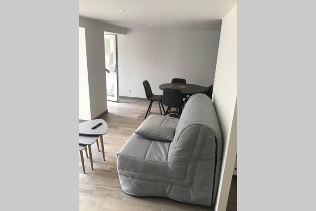 a living room with a couch and a table at Côté Mer - Maison (3P) au calme proche de la mer in Barneville-Carteret