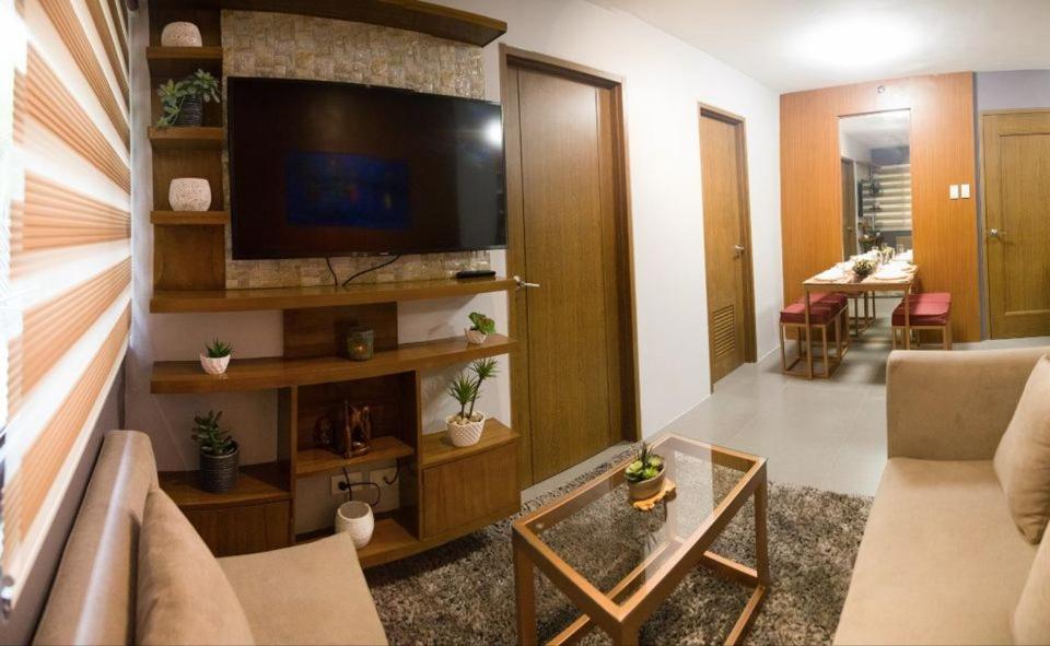 sala de estar con TV de pantalla plana y sofá en 2 Bedroom Condo Unit Fully Furnished, en Manila