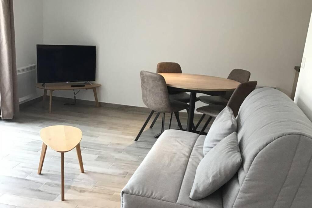 un salon avec un canapé et une table dans l'établissement Côté Dune - Maison (3P) au calme proche de la mer, à Barneville-Carteret