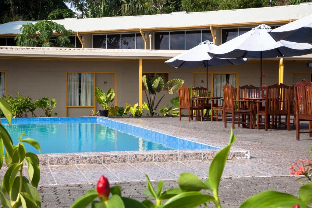 a villa with a swimming pool in front of a house at Huon Gulf Hotel in Lae