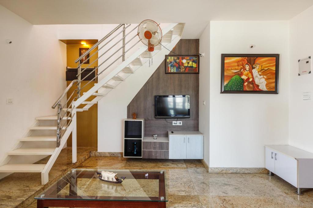 a living room with a staircase and a tv at Cosy Penthouse with High speed wifi-UPS near WTC-IISC in Bangalore